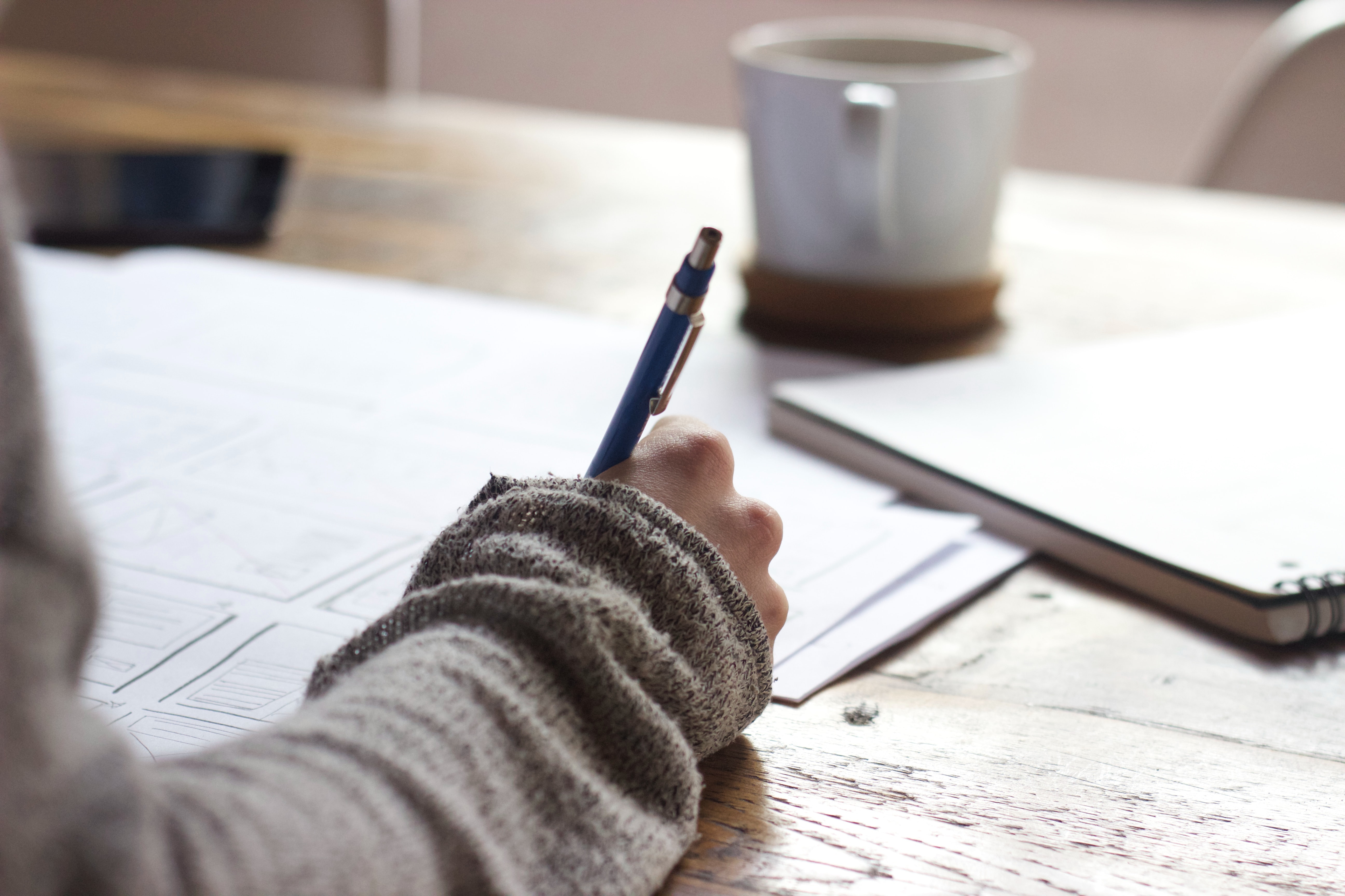 Image of Person Writing on Desk